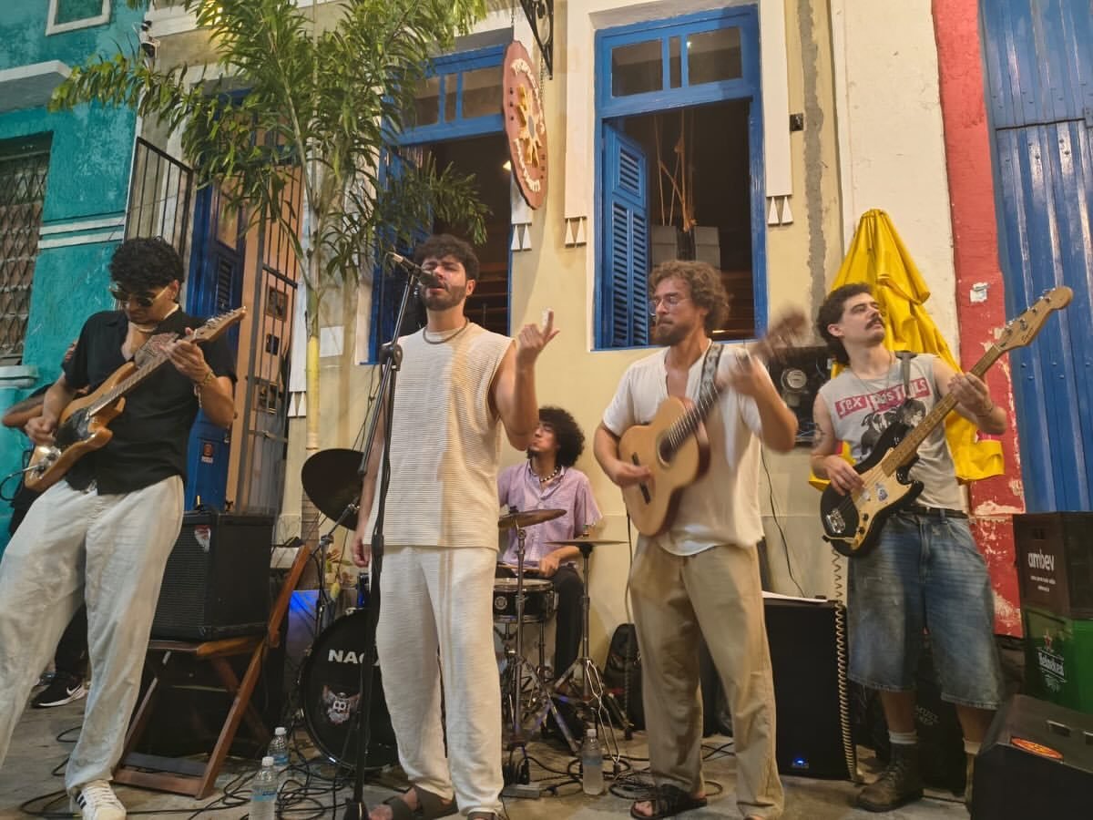 Roda de música na calçada, de tarde, em frente aos casarões da Osório